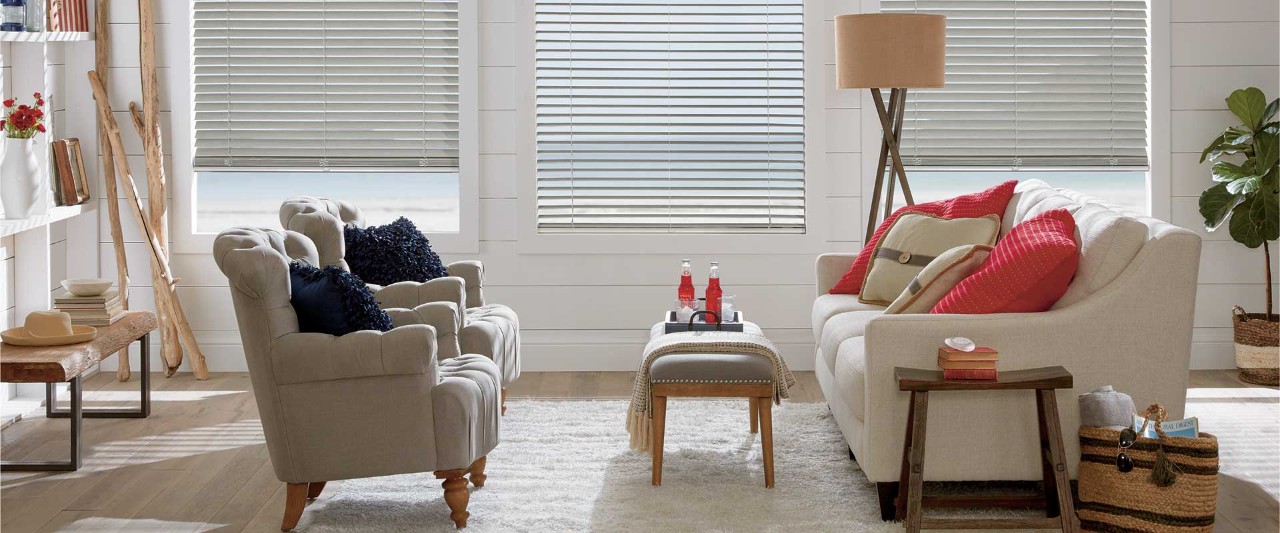 Coastal living room with couch and two chairs with alternative wood blinds.